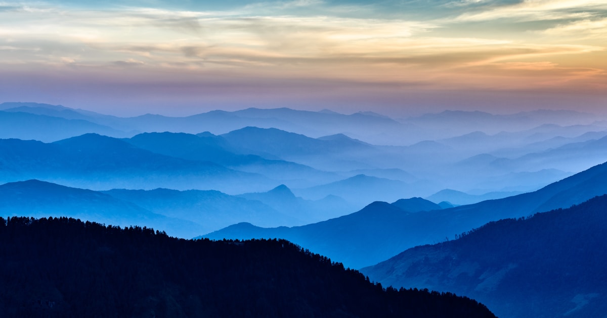 Dawn slowly emerging over a still mountain lake with low-lying fog — depression often lifts as integrated treatment takes hold, but the lift is slow and visible only in weekly increments