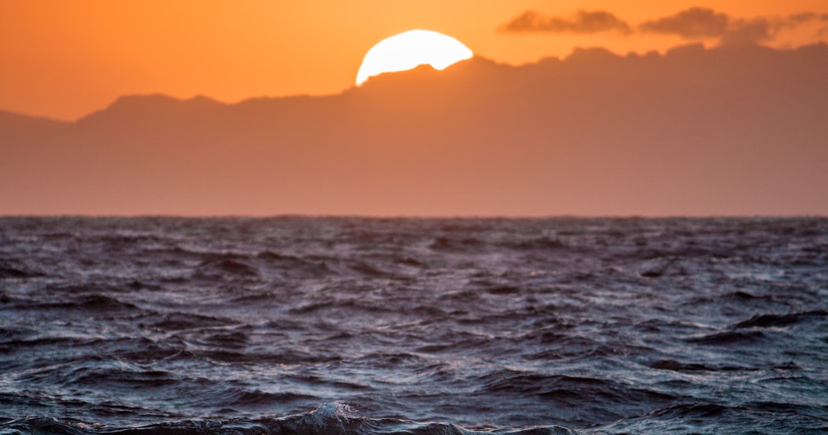 Abstract watercolor of sunrise over the sea behind a mountain ridge — the steadier ground a careful taper leads to