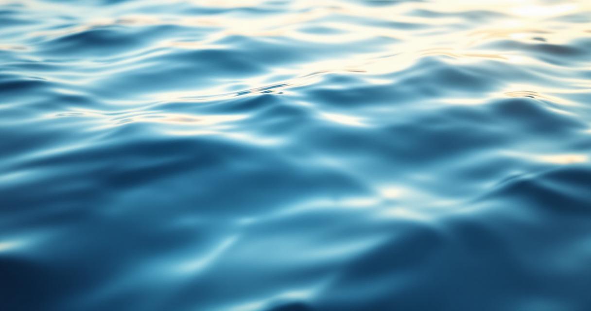 Abstract calm landscape of a gentle sunrise over still misty water, soft warm light