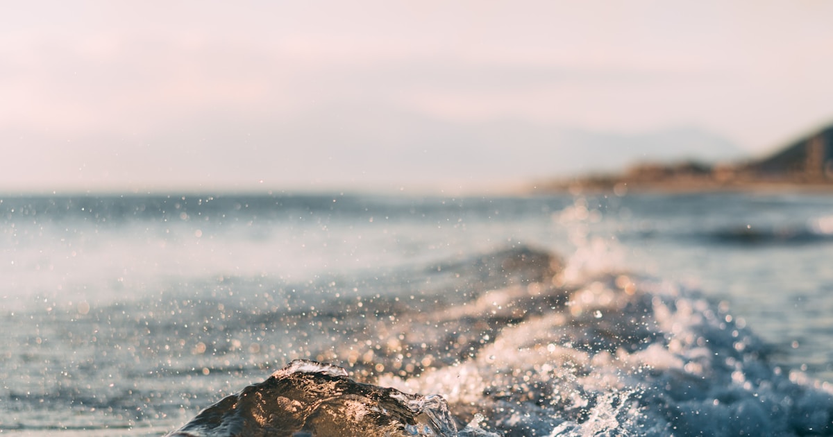 Abstract watercolor of a single wave cresting at sea and softening back into calm water — a craving observed and allowed to pass