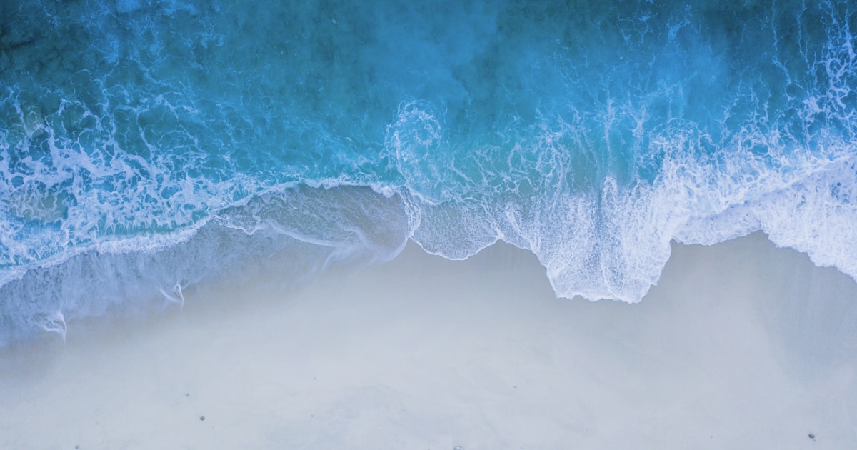Abstract watercolor of fresh ocean air over breaking waves seen from above — the clean breath that recovery restores
